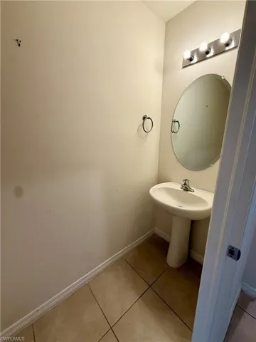 Bathroom with light tile patterned floors and baseboards