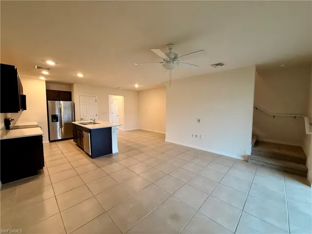 Kitchen featuring open floor plan, recessed lighting, stainless steel appliances, a kitchen island with sink, and dark cabinets