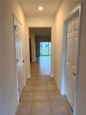 Hall featuring baseboards and light tile patterned floors