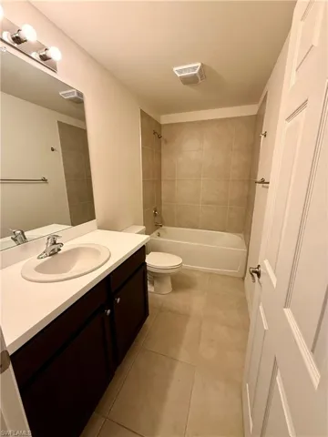 Full bath with  shower combination, vanity, and light tile patterned floors