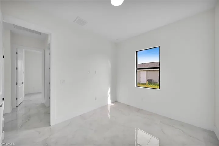Spare room with light marble finish floors