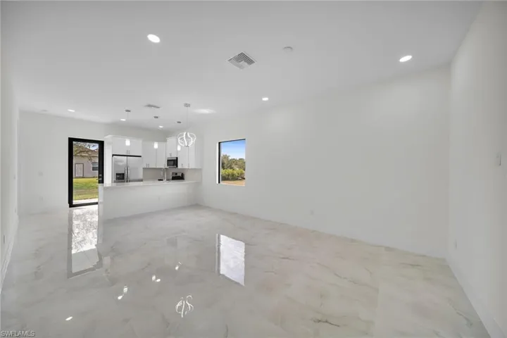 Unfurnished living room with recessed lighting and light marble finish floors