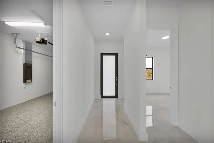 Hall featuring recessed lighting, electric panel, and light marble finish floors