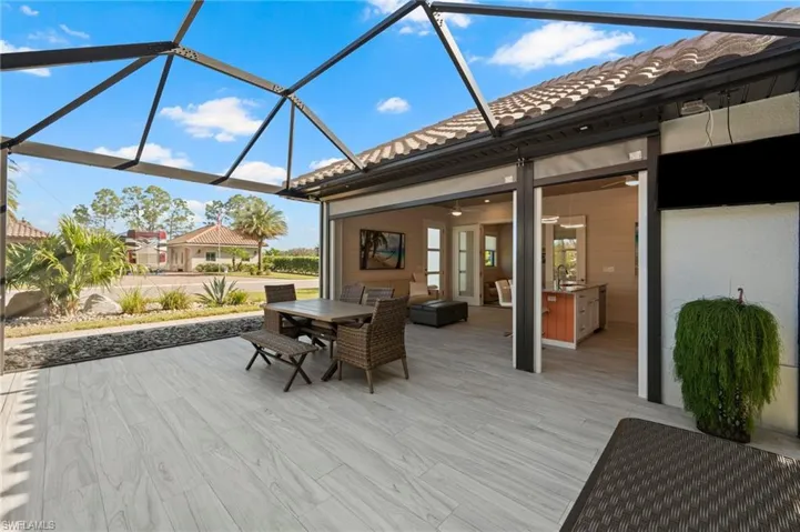 Deck featuring a lanai, outdoor dining area, and a sunroom