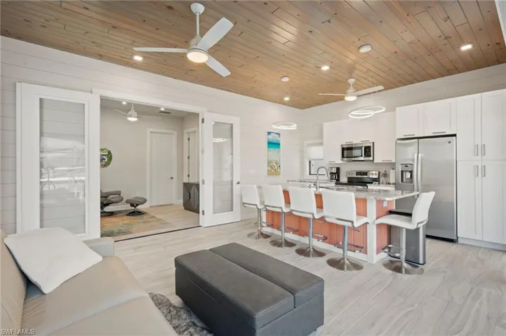 Living room featuring light wood-style flooring, recessed lighting, wood walls, and wood ceiling
