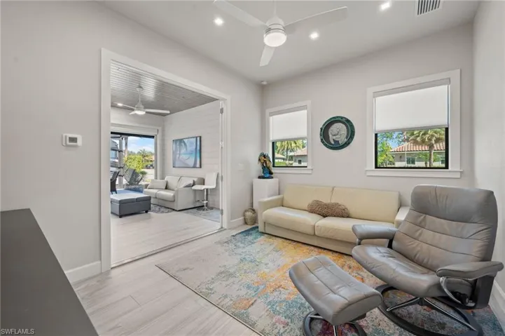 Living area with a ceiling fan, wood finished floors, and recessed lighting