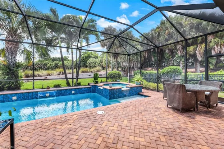 Pool with an in ground hot tub, patio and screened in lanai