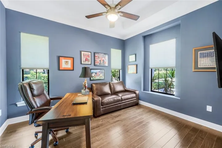 Office/den with wood-type flooring, crown molding, and ceiling fan