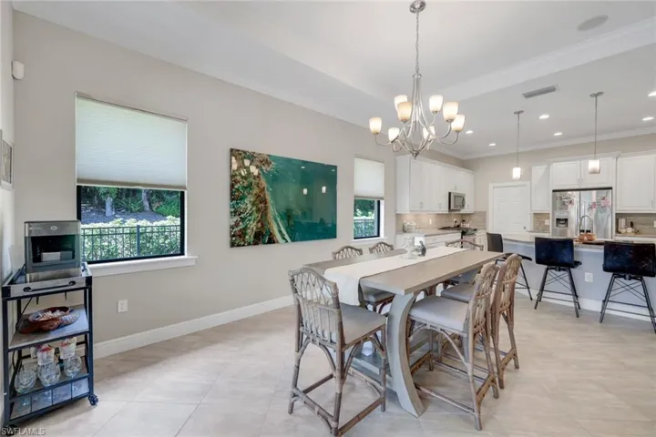 Tiled dining area with a chandelier and crown molding