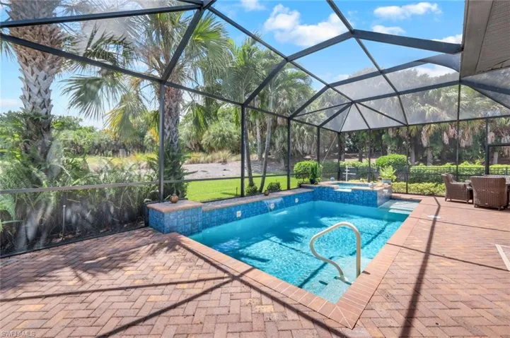 View of swimming pool with a lanai, in ground hot tub, and a patio