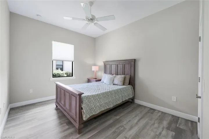 Guest bedroom #1 featuring wood-type flooring and ceiling fan