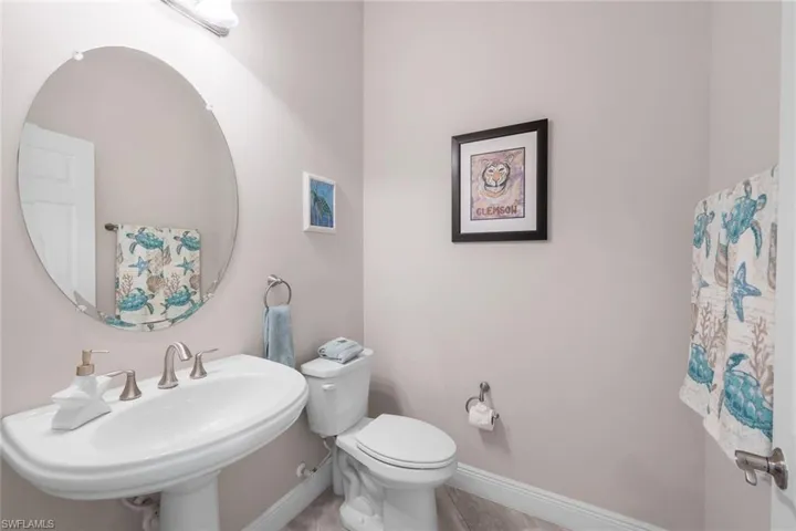 Half bathroom with tile patterned flooring, toilet, and sink