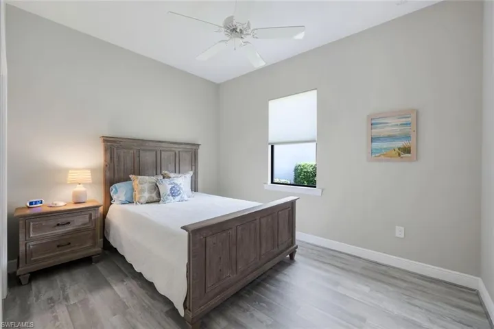 Guest bedroom #1 with wood-type flooring and ceiling fan
