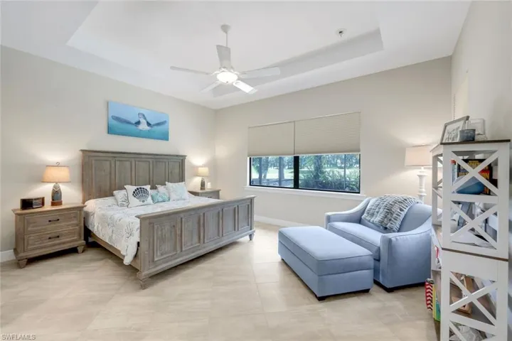 Primary bedroom featuring ceiling fan and a raised ceiling