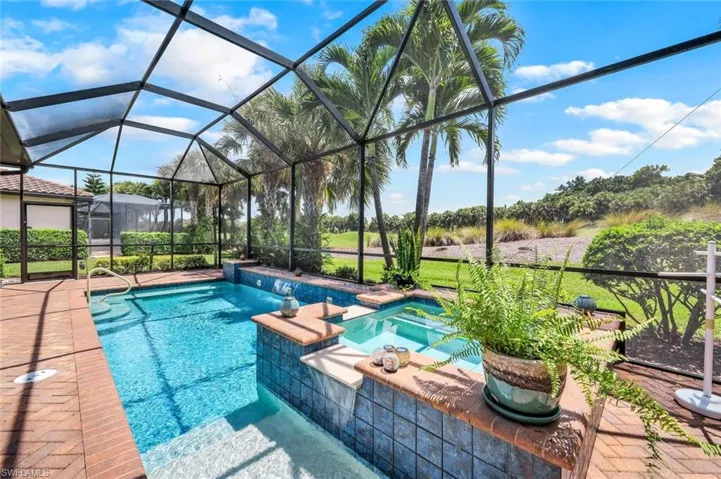 View of pool with a lanai and a patio