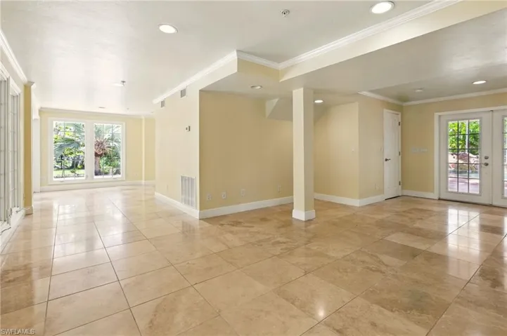 Unfurnished room with crown molding, plenty of natural light, baseboards, recessed lighting, and fire sprinkler in ceiling