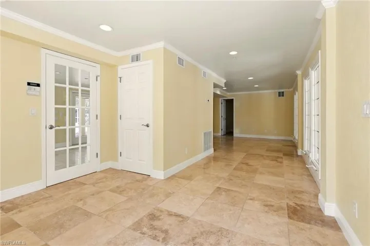 Empty room with crown molding, baseboards, recessed lighting, and french doors
