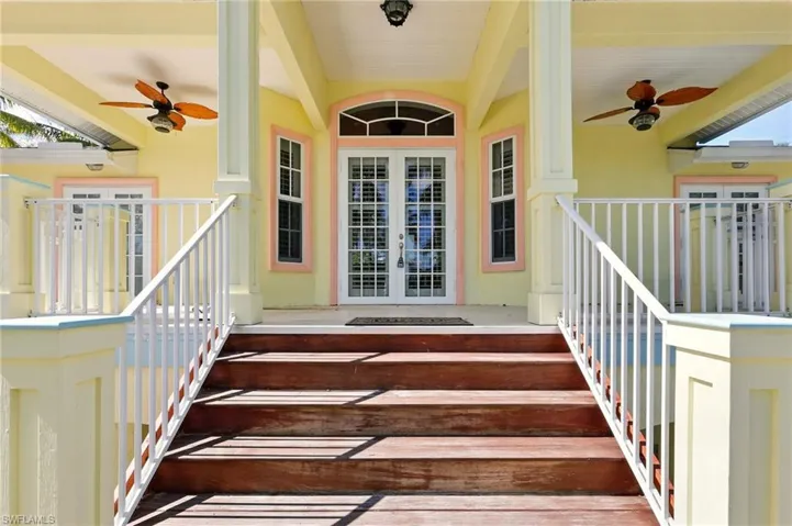 Doorway to property with ceiling fan, stucco siding, and french doors