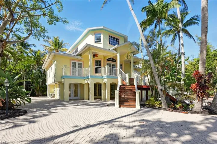 View of front of home featuring french doors, a carport, ceiling fan, stairway, and stucco siding