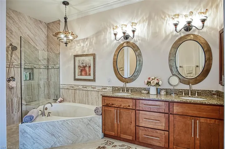 Bathroom featuring dual vanity, crown molding, tile patterned floors, and separate shower and tub