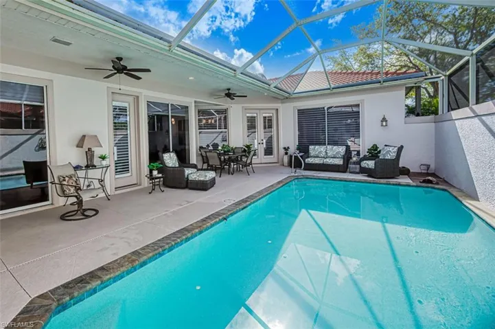 View of swimming pool featuring a patio, ceiling fan, and a lanai