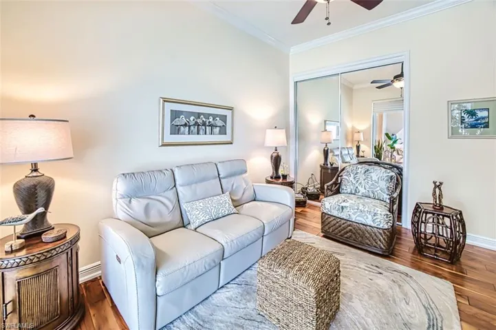 Living room with hardwood / wood-style flooring, crown molding, and ceiling fan