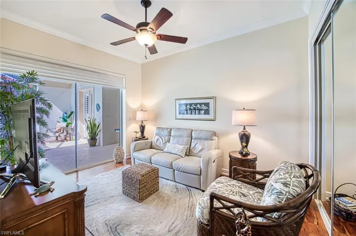 Living room with crown molding, ceiling fan, and hardwood / wood-style floors