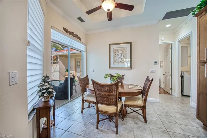 Dining room featuring light tile patterned floors, ceiling fan, and crown molding