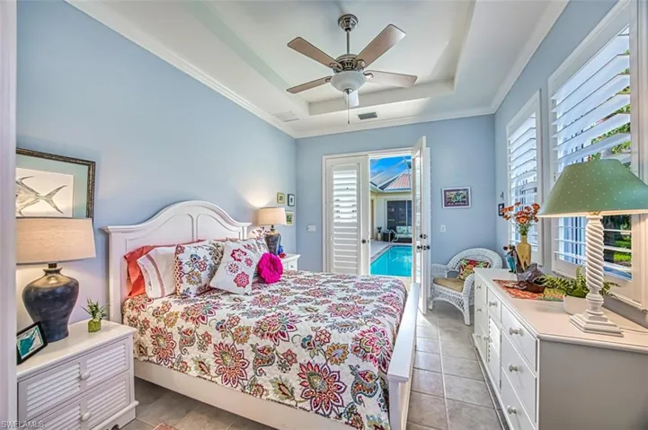 Bedroom with ceiling fan, ornamental molding, access to outside, a raised ceiling, and light tile patterned floors