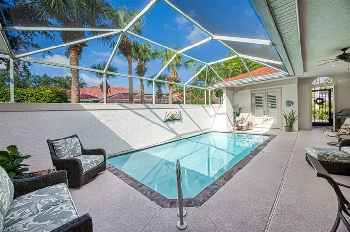 View of pool with a lanai, a patio, and ceiling fan