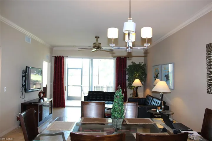 Tiled dining room with crown molding, a chandelier, and ceiling fan
