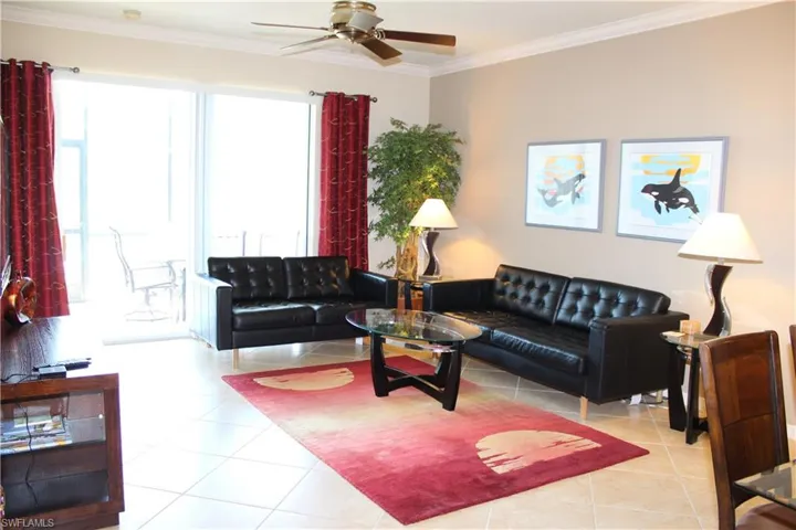 Living area featuring ornamental molding, light tile patterned flooring, and ceiling fan