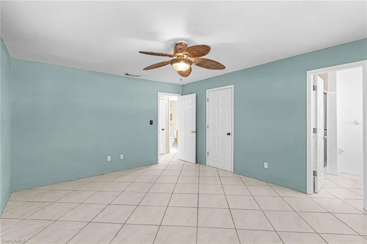 Unfurnished bedroom with ceiling fan and light tile patterned floors
