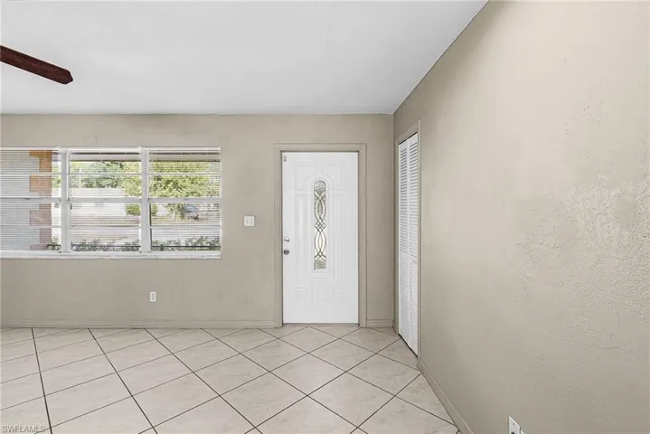 Foyer entrance featuring light tile patterned floors and ceiling fan
