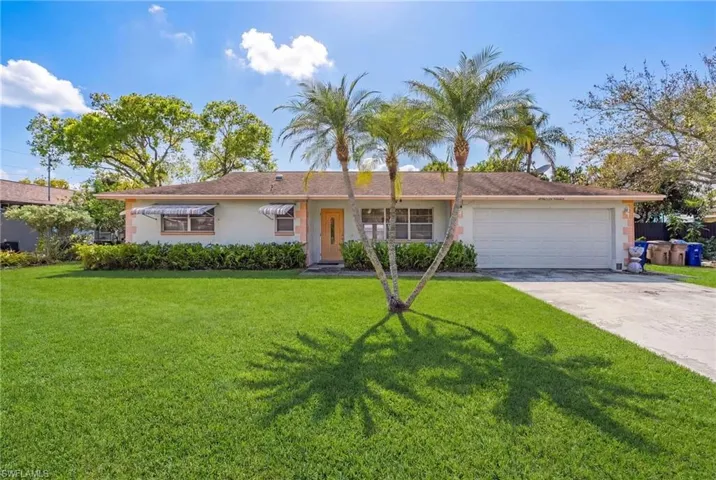 Ranch-style home with an attached garage, a front yard, concrete driveway, and stucco siding