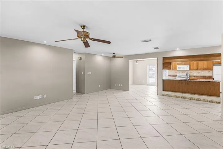 Unfurnished living room featuring light tile patterned floors, ceiling fan, and recessed lighting