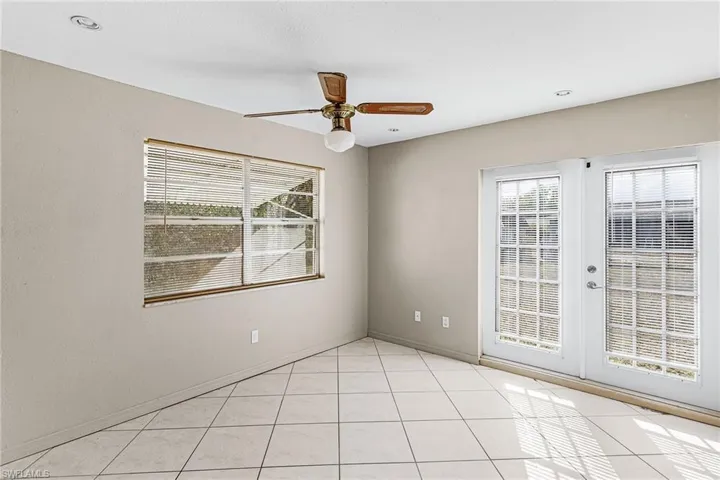 Unfurnished room with ceiling fan, light tile patterned flooring, and french doors