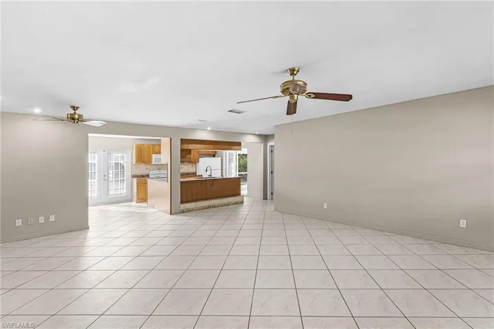 Unfurnished living room with ceiling fan and light tile patterned floors