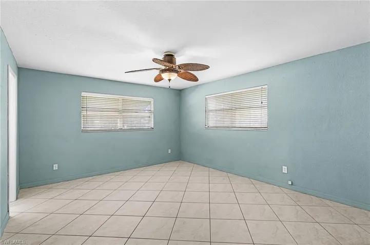 Spare room with ceiling fan and light tile patterned floors