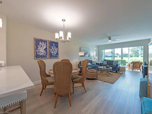 Dining area with ceiling fan, a chandelier, and light wood-style floors