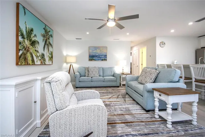 Living area with ceiling fan, wood plank tile floors, and recessed lighting
