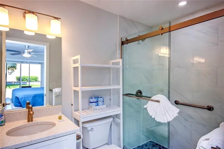 Primary Bathroom featuring a shower stall, vanity, and ceiling fan