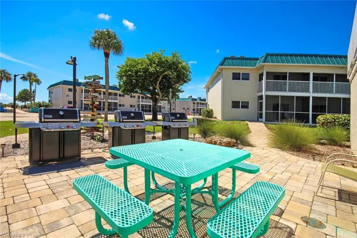 Community Patio / terrace featuring area for grilling, a sunroom, outdoor dining area, and a patio area