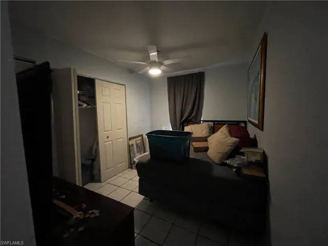 Unit 2: Bedroom with light tile patterned floors, a closet, and ceiling fan