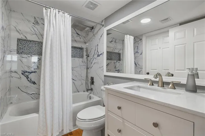 Full bathroom with shower / bath combo, toilet, and vanity