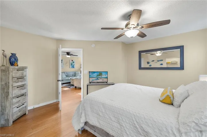 Bedroom featuring light hardwood / wood-style flooring, a textured ceiling, and ceiling fan