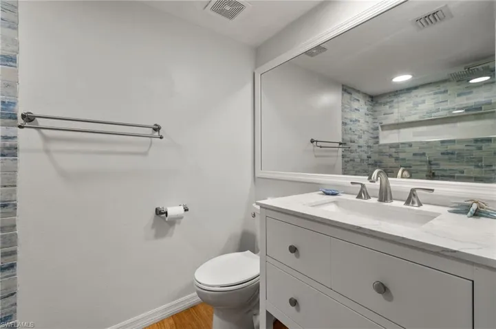 Bathroom featuring hardwood / wood-style floors, vanity, and toilet