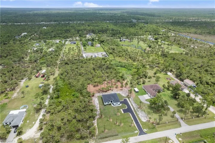 View of property location with a heavily wooded area