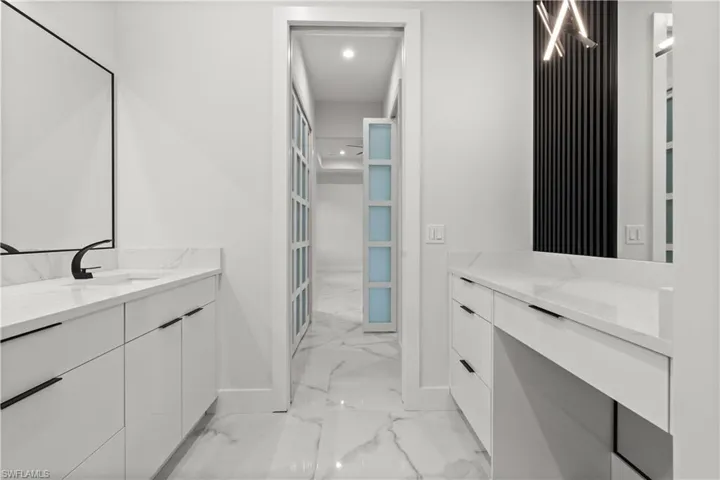 Full bathroom featuring marble look tiles, vanity, and recessed lighting