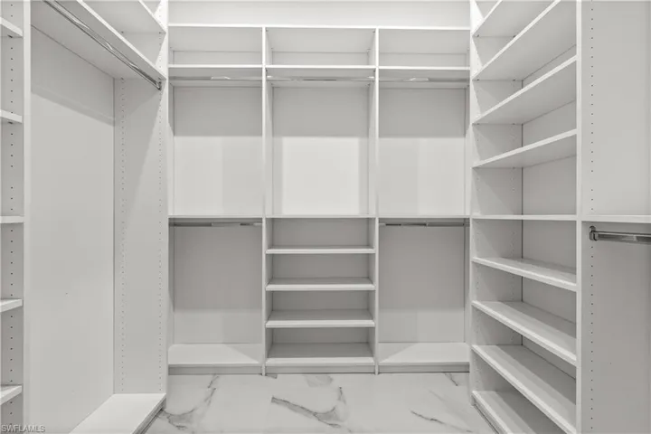 Walk in closet with marble finish flooring